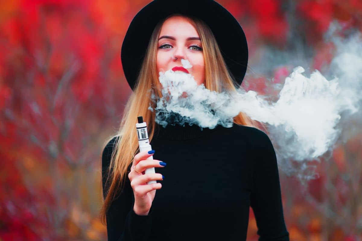 A lady vaping delta 8 thc outdoors