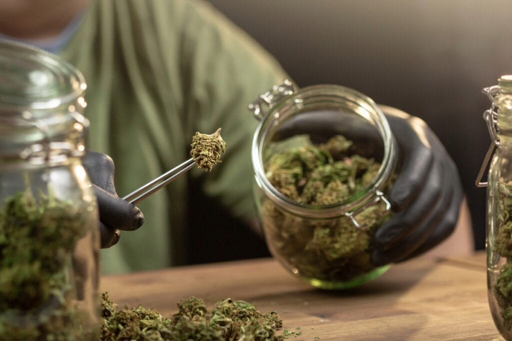 Person storing hemp products in glass jar